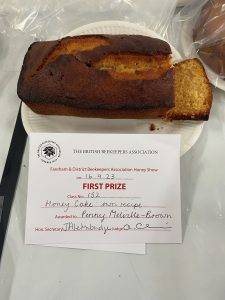 Golden brown loaf-cake with darker brown crust and first prize certificate.